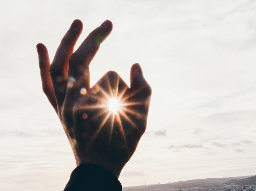 force perspective photography of hand and sun