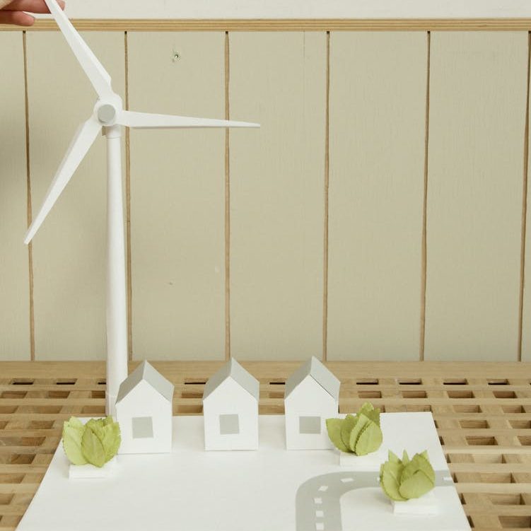 a scale model of houses and wind turbine on cardboard