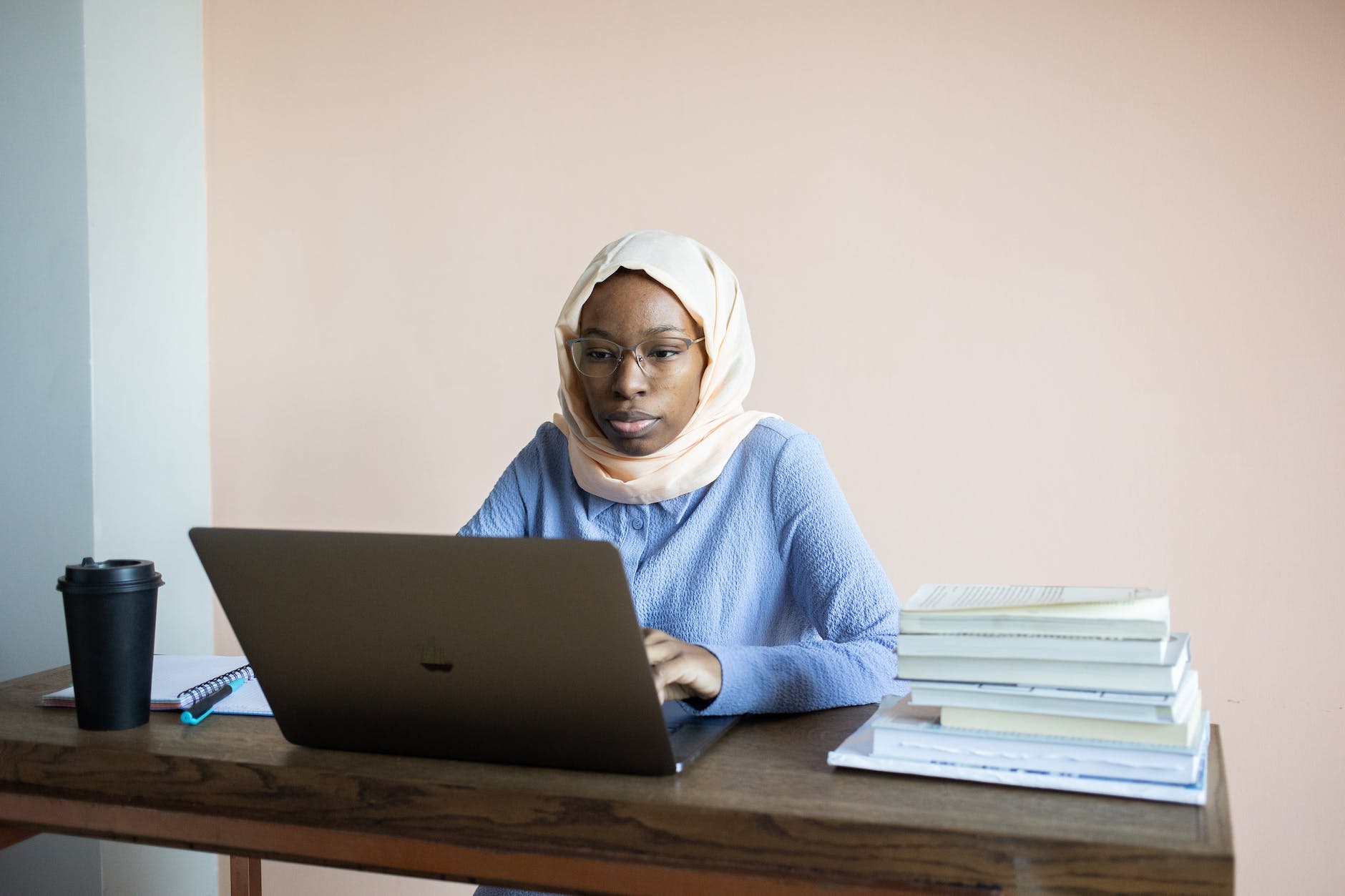 serious black woman typing on laptop during homework preparation