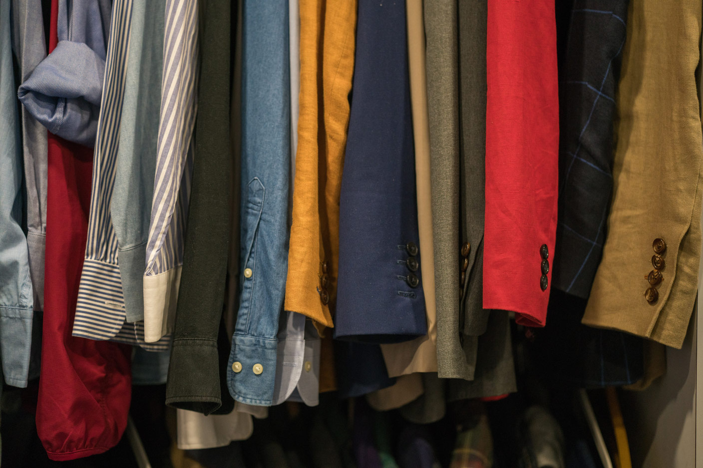 The picture shows clothes on hangers in a second-hand store