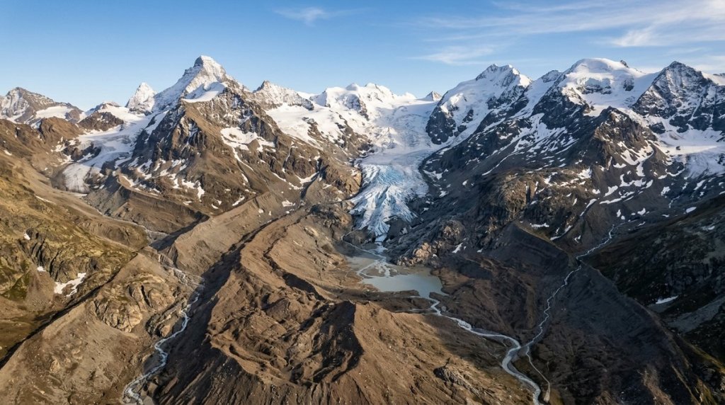 Aerial view of a retreating Swiss glacier exposing bare rocky moraine where ice has melted away in the Alps